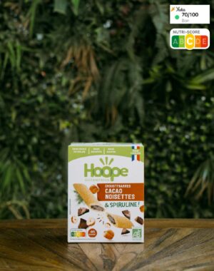 boîte de biscuits crousti'barres cacao noisettes posé sur une table en bois avec en arrière plan un mur végétal