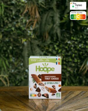 boîte de crousti'barres tout choco posée sur une table en bois avec en arrière plan un mur végétal