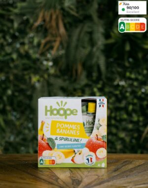 pack de 4 compotes de pomme & banane posé sur une table en bois avec un arrière plan végétal