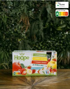 pack mix de compotes posé sur une table en bois avec un arrière plan végétal